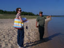 On the banks of Lake Michigan, Kacy conducts a field survey with an Odawa natural resources specialist